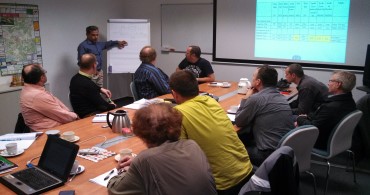 Trainer leading a workshop session with participants around a conference table