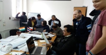 International participants working through drawings and reports in a group exercise