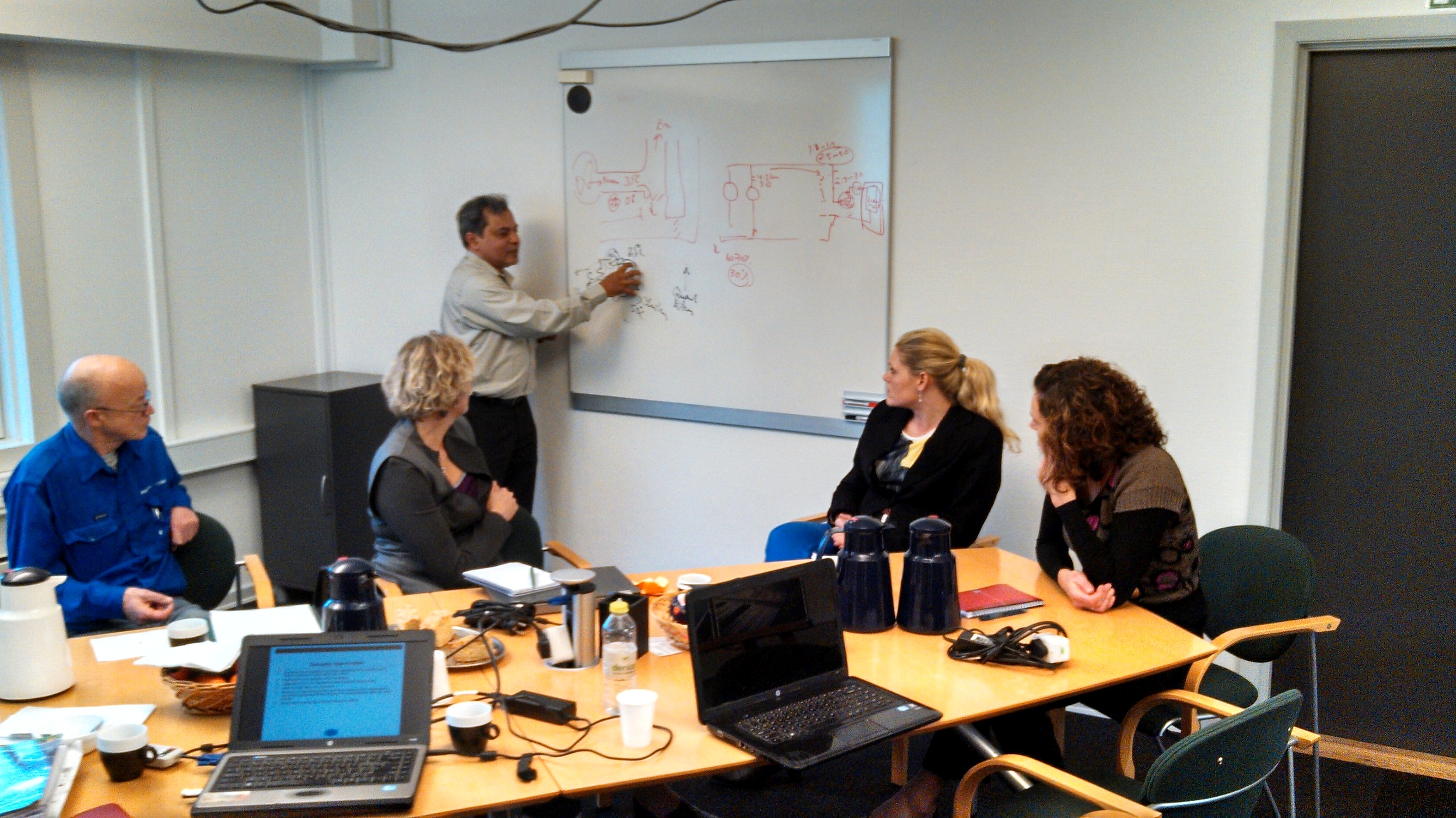 Trainer explaining a process schematic on a whiteboard during a technical session