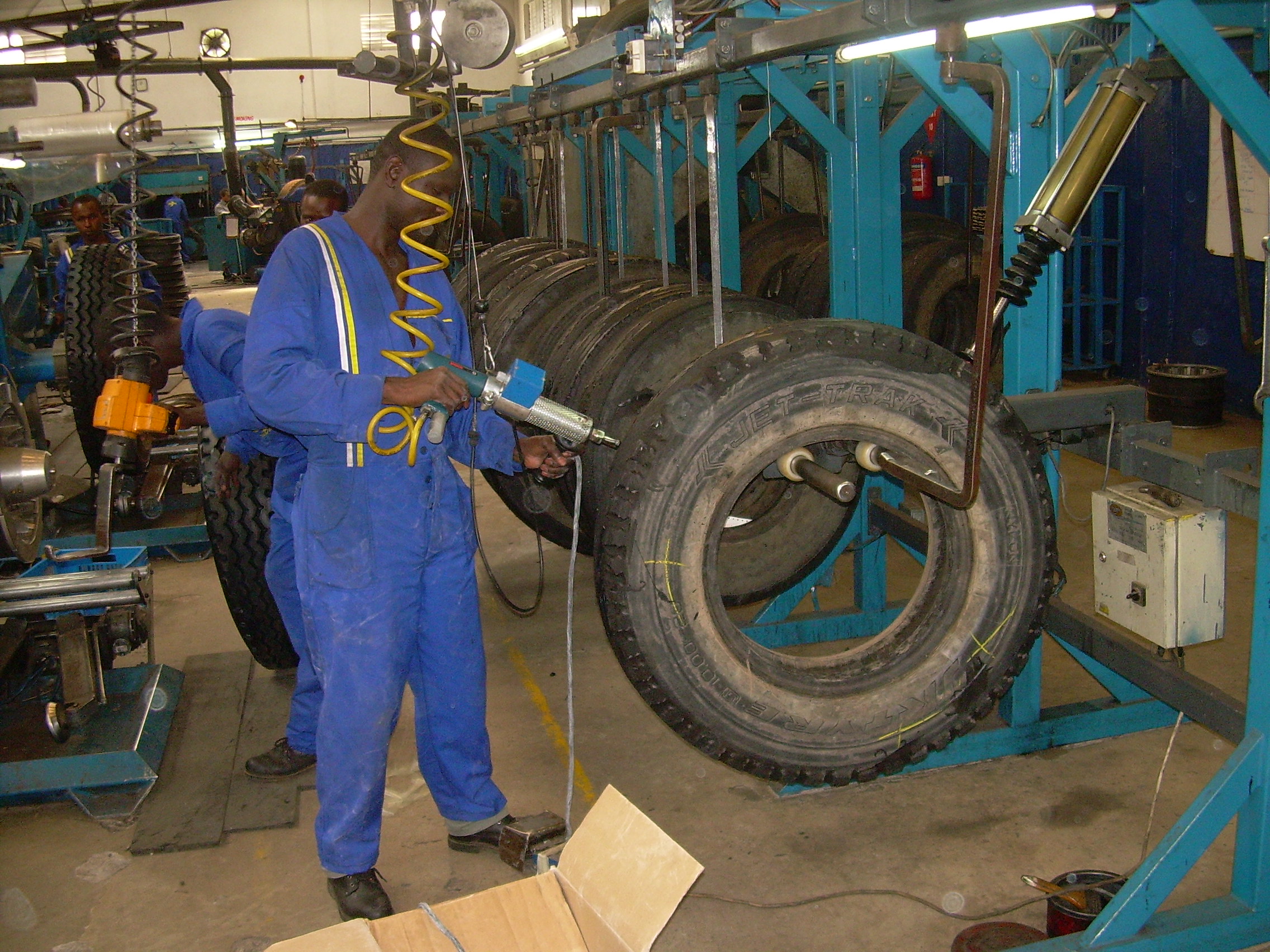 Technician working on a tyre retreading line during a plant energy audit